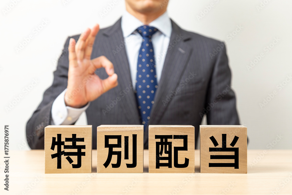 Obraz premium 「特別配当」と書かれたブロックとOKポーズをするビジネスマン