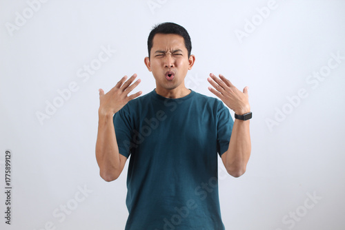 Asian man feeling hot, sweating and fanning himself in heatwave