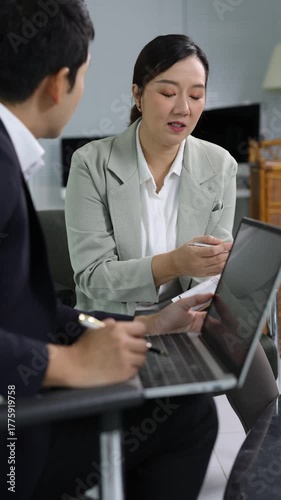 Professional business partners collaborating during strategic project meeting, exchanging ideas and analyzing documents while working together in corporate office.