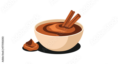 Delicious bowl of rich chocolate dessert or warm beverage topped with aromatic cinnamon sticks and a side dollop, ready to enjoy.