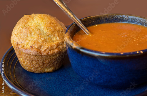 Warm Corn bread muffin with a creamy bowl of  tomato soup