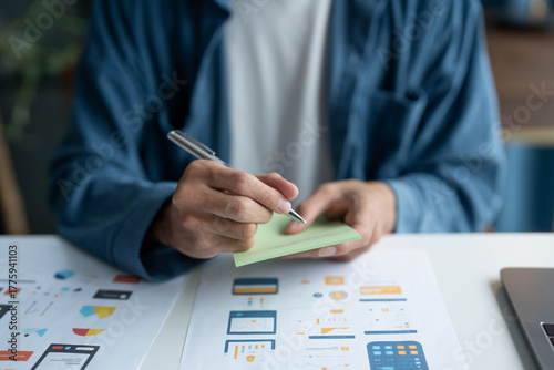 UX UI Designer Planning innovative Mobile App with Paper Wireframe Designs at Workspace.