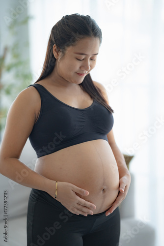 Pregnant asian woman holds hands on belly touching her baby caring about her health Beautiful happy pregnant woman tender mood photo of pregnancy. Free Download Pregnant asian woman holds hands on belly touching her baby caring about her health Beautiful happy pregnant woman tender mood photo of pregnancy. - GFXLoad