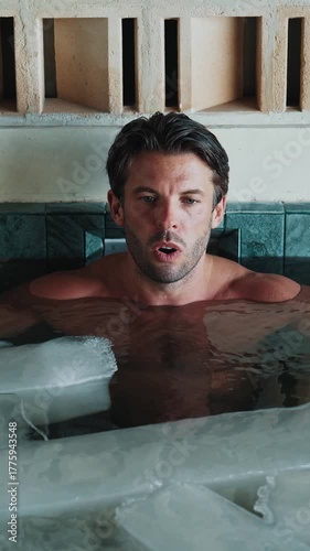 Attractive Man Dives into Cold Water of Swimming Pool with Ice Cubes for Good Body Health. Fit Person in Bathtub Filled with Frost Liquid for Youth Treat. Winter Routine of Healthy Male in Floor Bath