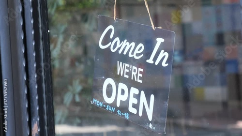 Welcome sign invites visitors to a local shop in the city