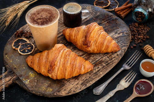 Fresh croissants in the plate at the hands of two women