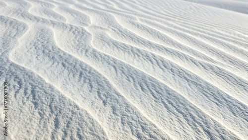 Abstract ripples of white sand dunes under bright sunlight