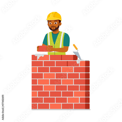 African American bricklayer holding brick behind brick wall wearing safety vest and helmet