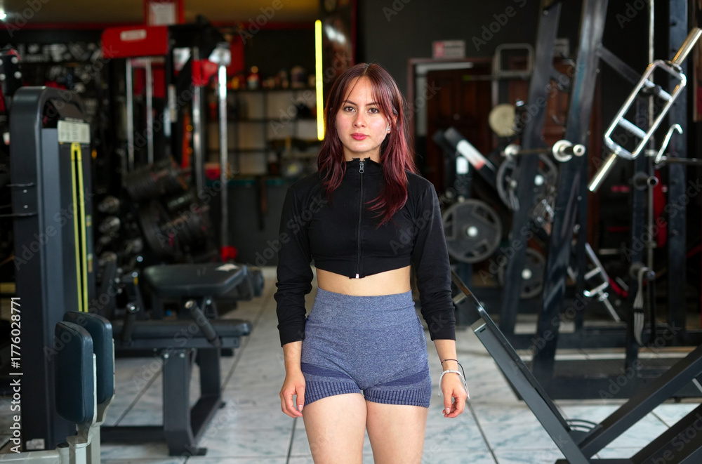 Fototapeta premium Young woman standing in gym ready for workout