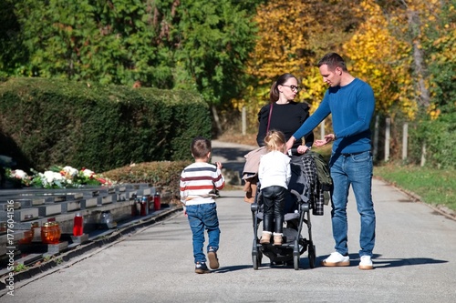 Young family at the cemetery for All Saints' Day