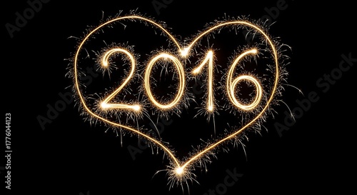 Sparkler light painting creating the number 2016 framed by a golden, glowing heart on a black background