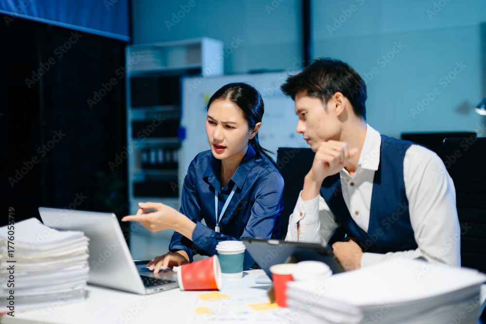 Fototapeta premium Asian business colleagues feeling stress and fatigue from workload, working late under deadline pressure and tension in modern office.