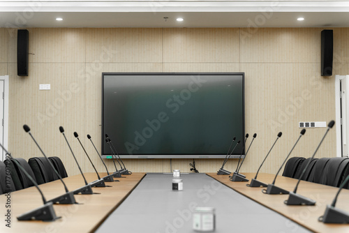 modern conference room with a large screen, multiple microphones