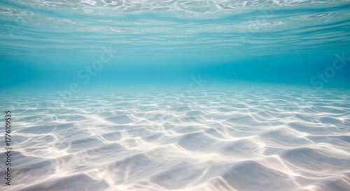 Fototapeta Naklejka Na Ścianę i Meble -  Calm and clear underwater perspective of the sandy ocean floor with natural ripple patterns created by sunlight filtering through the turquoise sea surface