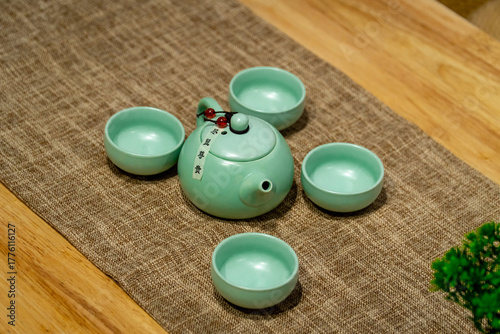 A set of jade green teapot on a cloth pad on the table.