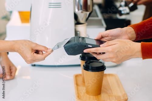 Contactless payment, Customer using credit card for making payment at cafe restaurant. Close up of woman using card for paying , shop owner receiving payment from customer in coffee shop.