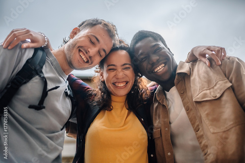 Fotografia Happy multi-ethnic students embracing and smiling outdoors