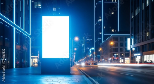 A glowing blank billboard stands on a quiet modern city street at night, illuminated by vibrant blue neon lights