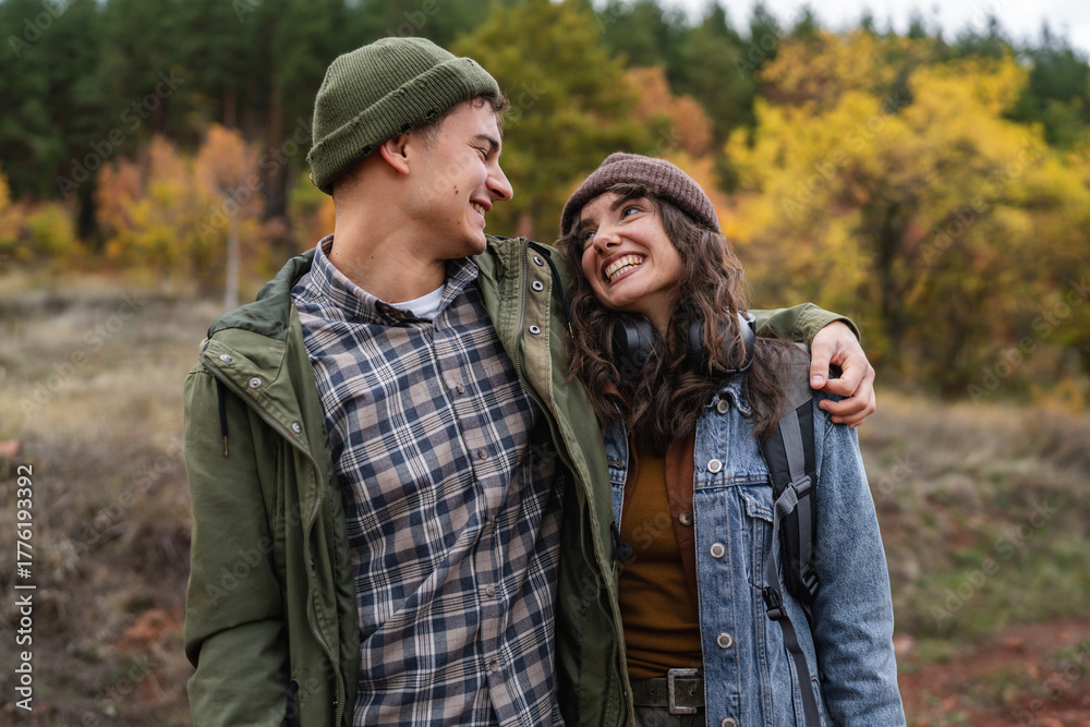 Fototapeta premium Young couple enjoying autumn hike, guy pointing finger
