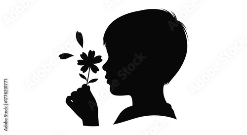 Silhouette of a young child s profile smelling a delicate flower against a white background