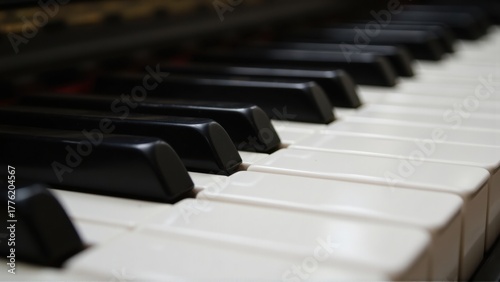 Close-up of piano keys with alternating black and white keys, shallow depth of field highlighting texture, reflections, and musical detail.