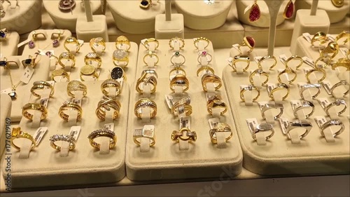 Women's gold jewelry, rings, earrings, bracelets and necklaces with precious stones in the shop window	