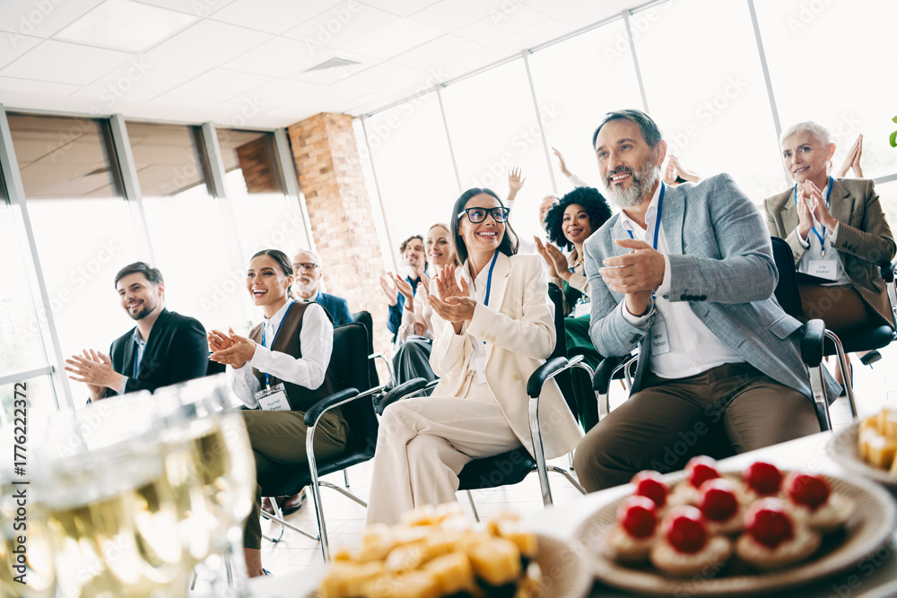 © deagreez - Group of business professionals celebrating success in an office with food and refreshments, showcasing teamwork and collaboration