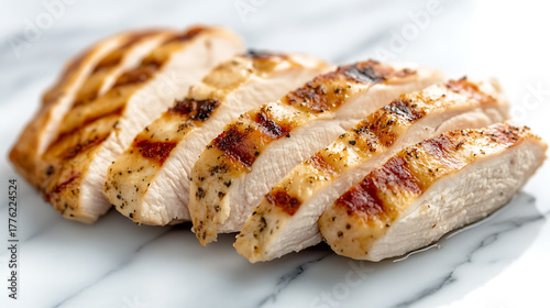 Slices of perfectly grilled chicken, ready to eat! The chicken is juicy and tender, and the grill marks add a touch of smoky flavor. Great for a meal!