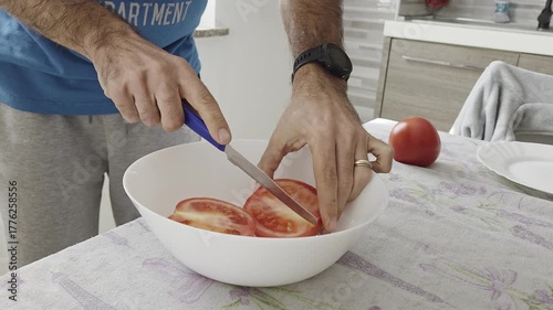 Man Slicing Fresh Tomatoes into Ceramic Bowl