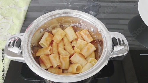 Man Mixing Macaroni with Fresh Tomato Sauce