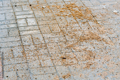 Closeup of sand on paving slabs used for road traction control during icy winter weather ensuring pedestrian safety on slippery pavements