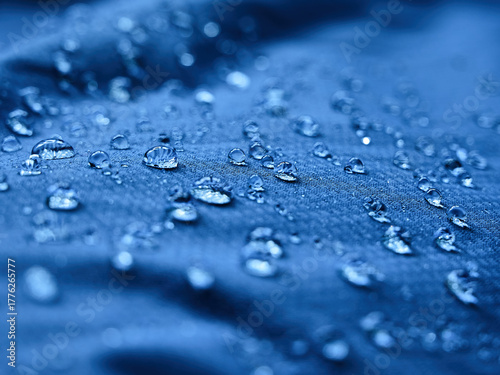 Water drops on waterproof membrane fabric. Detail view of texture of blue waterproof cloth.