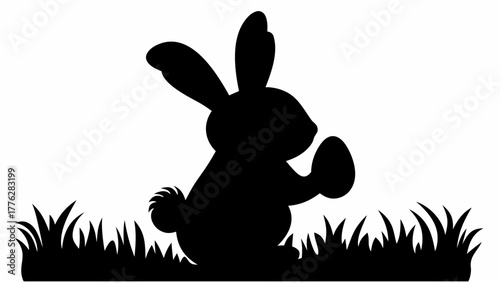 Silhouette of easter bunny holding an egg standing in grass against a white background design element
