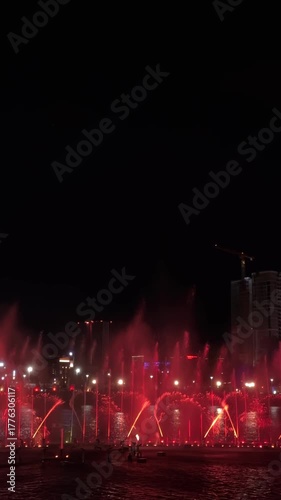 Musical fountain with colorful illuminations at night. Vertical video.