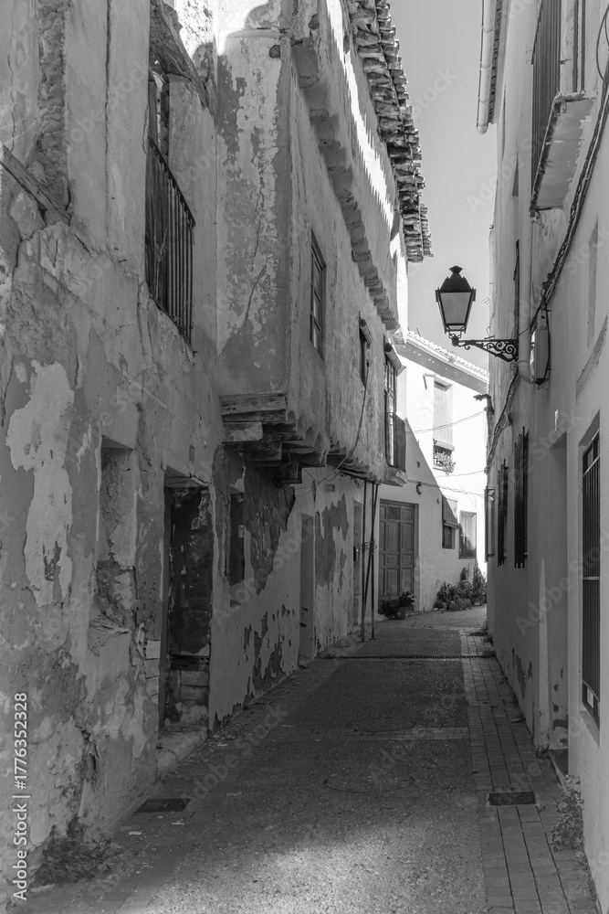 Obraz premium antigua calle medieval con paredes blancas con macetas de flores y pavimento de piedras en Requena, Valencia, Spain