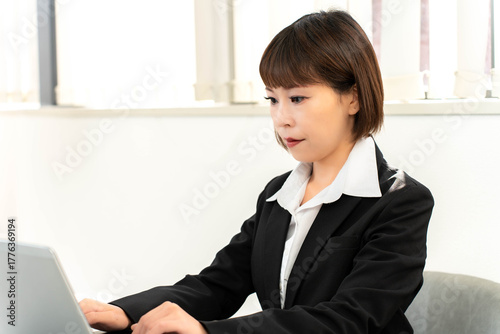 ノートパソコンで仕事をする女性社員