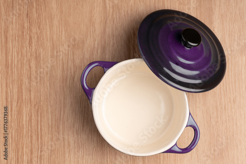 close up of a empty mini crock pot, in dark purple on a wooden table background