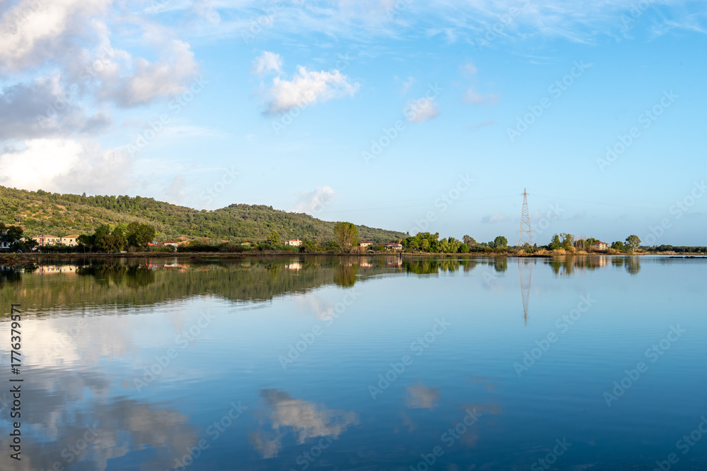 Fototapeta premium Land, sky and cloud reflections on the still waters of a wetland wildlife habitat.