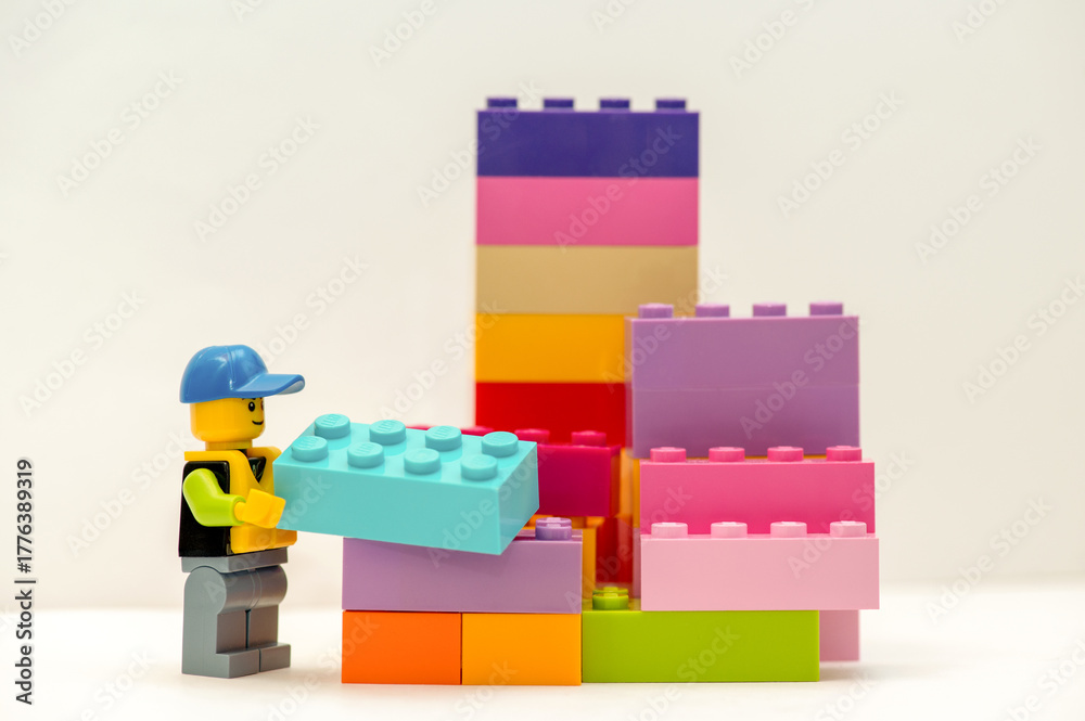 Naklejka premium LEGO miniature worker carrying a Lego brick. Educational children's toys. 