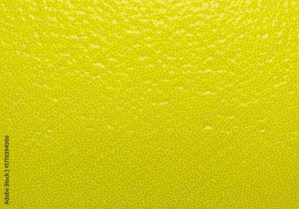 Obraz premium Abstract macro background of a fresh yellow citrus fruit peel creating a dotted texture pattern