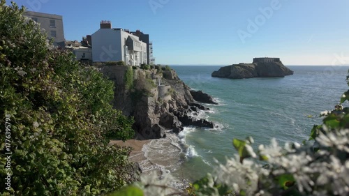 Tenby south beach at high tide with St Catherines Island in the distance on a bright sunny day.