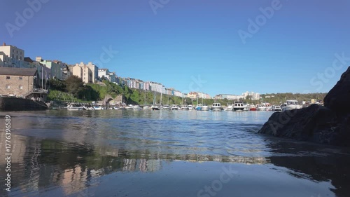 Boats moored in Tenby harbour at high tide on a bright sunny day.