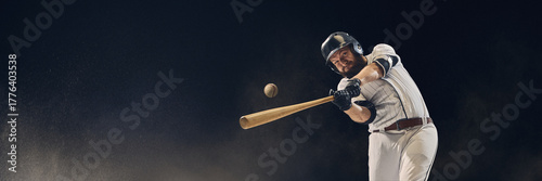 Obraz na plátně Baseball batter hitting ball midair with dust in the air showing perfect timing and precision