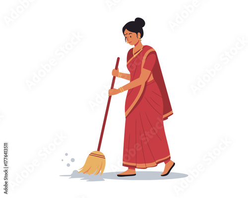 Young indian woman in traditional red saree sweeping the floor with a broomstick outdoors