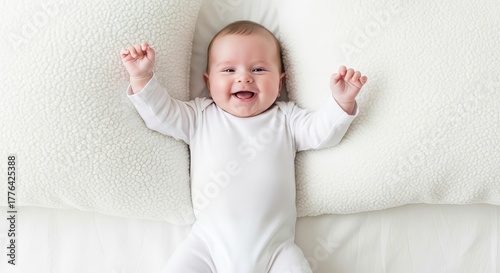Joyful baby lying on a soft white pillow expressing happiness and contentment at home with innocent glee