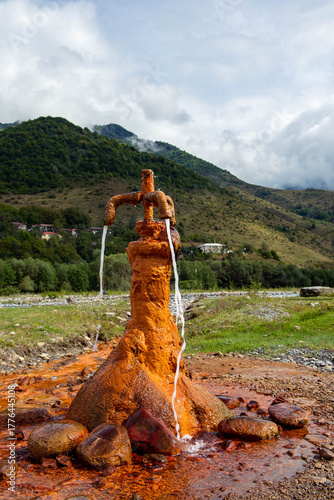 Old rusted public water tap in the mountains, Caucasus Russia