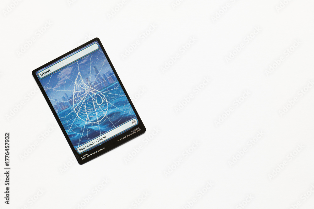 Obraz premium Bradford, UK Nov 3 2025 Basic Land Island card from the Spider-man magic the gathering card game shot isolated on a white paper background.