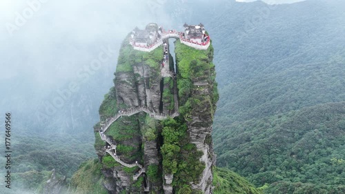 Aerial view of Fanjingshan Temple atop a striking rock formation amidst the lush green landscape, Fanjingshan, Guizhou, China.
