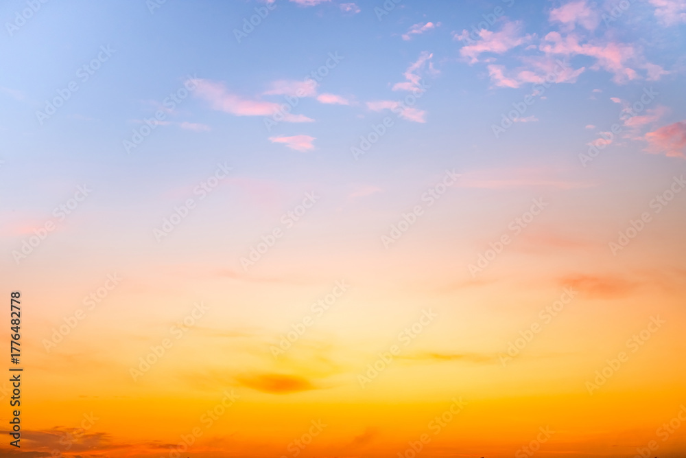 Fototapeta premium Sunset or sunrise sky with a vibrant gradient of orange, gold, and soft blue. Clear atmosphere with wispy clouds. Peaceful, natural light background. hope, freedom, new day and inspirational Concepts