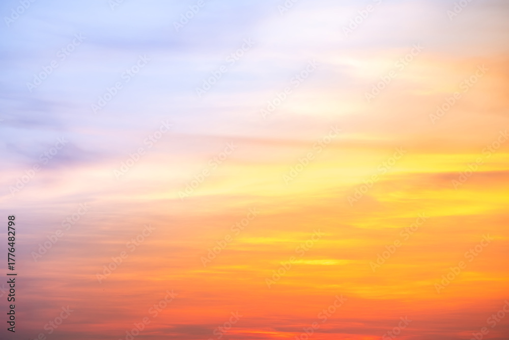 Fototapeta premium Sunset or sunrise sky with a vibrant gradient of orange, gold, and soft blue. Clear atmosphere with wispy clouds. Peaceful, natural light background. hope, freedom, new day and inspirational Concepts